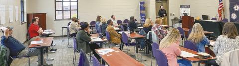 Ashley Prager (at podium) shares statistics at the Dec. 10 Suicide Prevention Coalition meeting held in the Community Room at Jones County High School. DEBBIE LURIE-SMITH/Staff