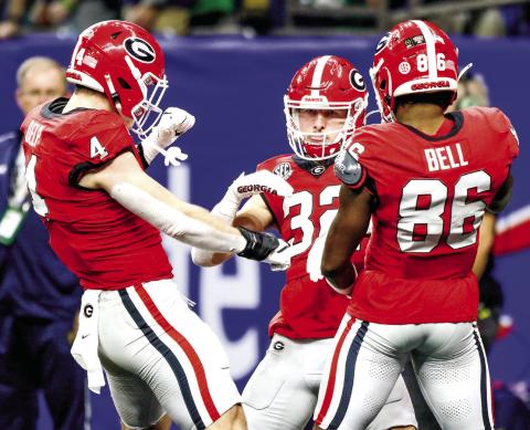 Georgia running back Cash Jones (32) celebrates with teammates Oscar Delp (4) and Dillon Bell (86) after scoring the team’s only touchdown in the third quarter of the Sugar Bowl against the Fighting Irish. LANCE McCURLEY/Staff