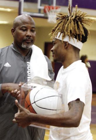 Greyhounds head coach Buck Harris presents Jaylen Sanford with a basketball commemorating his 1,000th career point prior to last Tuesday’s game against Union Grove. BRAD HARRISON/Staff