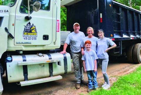 John McIntosh with his family in front of one of their trucks and other equipment used for JME Excavation. CONTRIBUTED BY JESSICA MCINTOSH