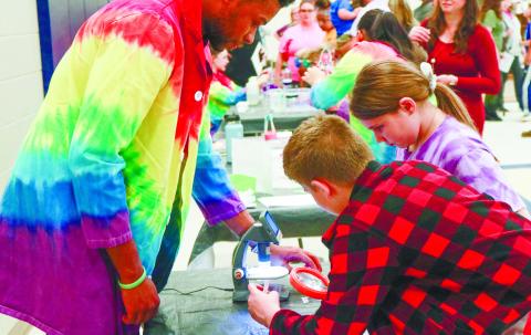 Students at Gray Elementary School looking through a microscope at the forensics table during Title I Science Night. NATHAN CLARKE/Contributed