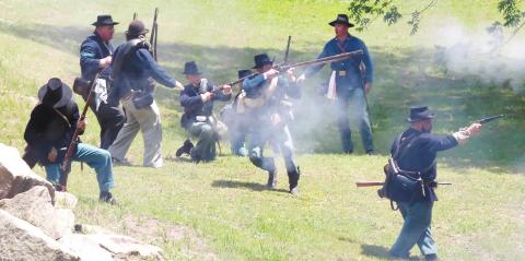 Soldiers from both sides fire their weapons at each other at the re-enactment at Old Clinton War Days. NATHAN CLARKE/Contributed