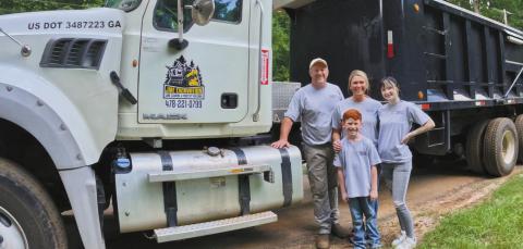 John McIntosh with his family in front of one of their trucks and other equipment used for JME Excavation. CONTRIBUTED BY JESSICA MCINTOSH