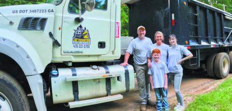 John McIntosh with his family in front of one of their trucks and other equipment used for JME Excavation. CONTRIBUTED BY JESSICA MCINTOSH