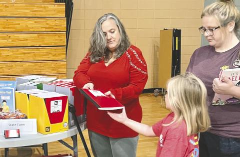 A student receives a notebook from one of the vendors giving out school supplies at the Back to School Bash. ALAINA CLARKE/Staff