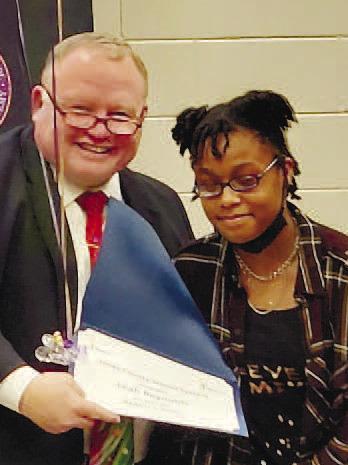 Superintendent Mr. Lundy awards Leah Reynolds, CRMS student her certificate as a 22-23 REACH Scholar recipient at the Dec. 5 signing ceremony. CONTRIBUTED