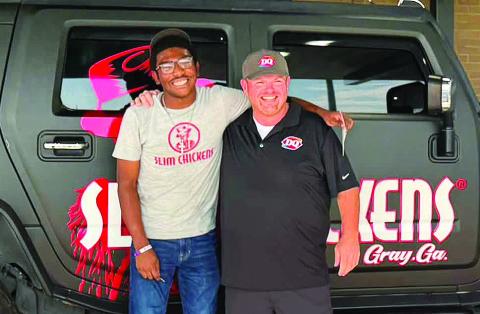 Antonio Gibson (left) was more than surprised when his boss Justin Kelly handed him the keys and clear title to the Slim Chickens Hummer after work Sept. 18. CONTRIBUTED