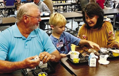 Grandma and grandpa enjoying breakfast during Grandparent’s Day at Dames Ferry Elementary School with a student.