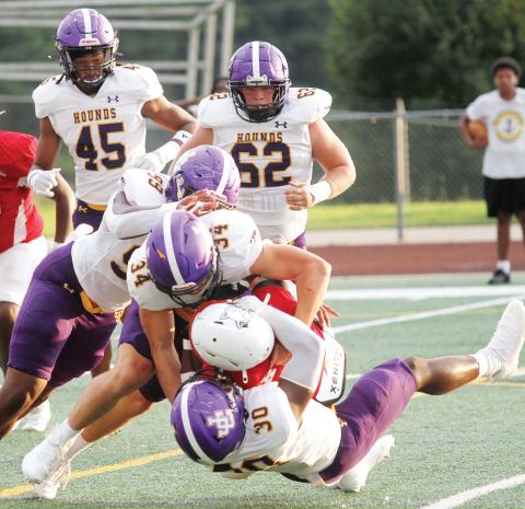 Thad Smith (34), Anthiny Seabrooks (30), and Machai Bellamy lead a gang tackle of a Woodland ball carrier during Friday’s game. BRAD HARRISON/Staff