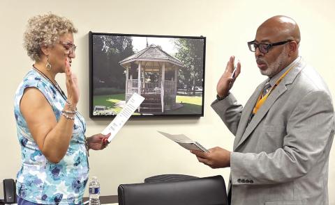 Jones County Interim School Superintendent Clinton Burston receives his board member oath from Jacquiline Mitchell with the North Central Health District. DEBBIE LURIE-SMITH/Staff