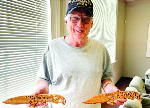 Jones County veteran and Veterans Committee member Roger Hawke holds two of his carvings of combat weapons to be distributed at this year’s event. DEBBIE LURIE-SMITH/Staff