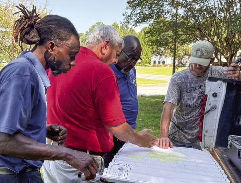 Georgia Rural Water and Gray Water Department officials look at a map of Gray’s 70 miles of water lines while looking for a solution last week. DEBBIE LURIE-SMITH/Staff