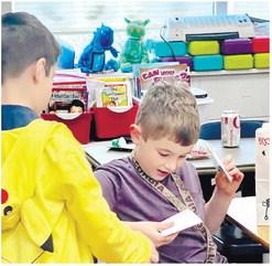 Benjamin Rader accepts a Valentines card from another student in his first-grade class at Dames Ferry Elementary School. ALAINA CLARKE/Staff