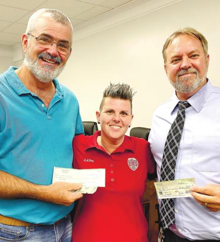 Chris Weidner (left) meets Sam Kitchens’ challenge to benefit animals in the Jones County. Jennifer Allen gladly accepted the donated funds of $2,002. DEBBIE LURIE-SMITH/Staff