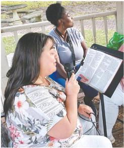 Volunteers take their turn reading from the Bible at Carol’s Park. CONTRIBUTED