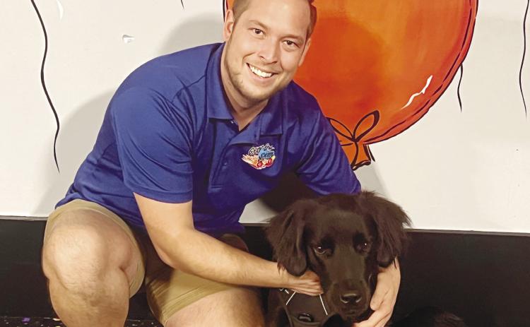 Joel Shiver, the owner of Gray-8-Skate Family Entertainment Center, with his new dog, Rink. ALAINA CLARKE/Staff
