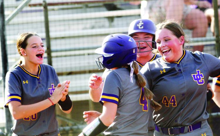 Raylee Harris (4) is mobbed by her teammates as she cross home plate after ripping a homer last week against Locust Grove. BRAD HARRISON/Staff